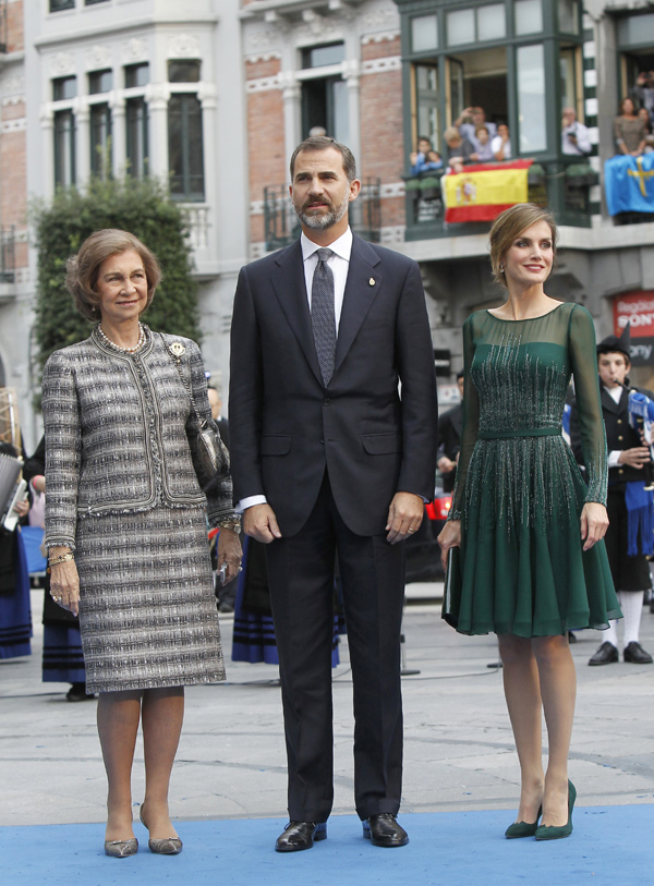 Los príncipes llegaron al teatro Campoamor acompañados de doña Sofía. Estilísticamente, no fue el mejor día de la reina. El príncipe podía pedirle consejo a Carlos de Inglaterra (vamos, con la planta que tiene podría hacerlo mucho mejor). Letizia, con un vestido "en georgette de seda verde Veronés, bordado en cristal jade, esmeralda y black Diamond, todo ello completado con un pochette en charol y zapatos en ante al tono".